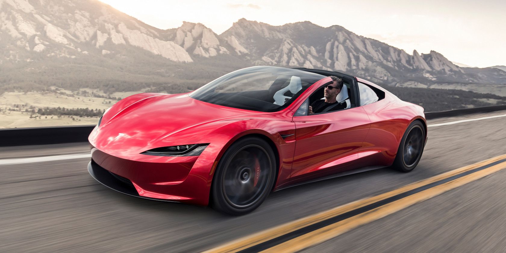 Red Tesla Roadster con le montagne sullo sfondo