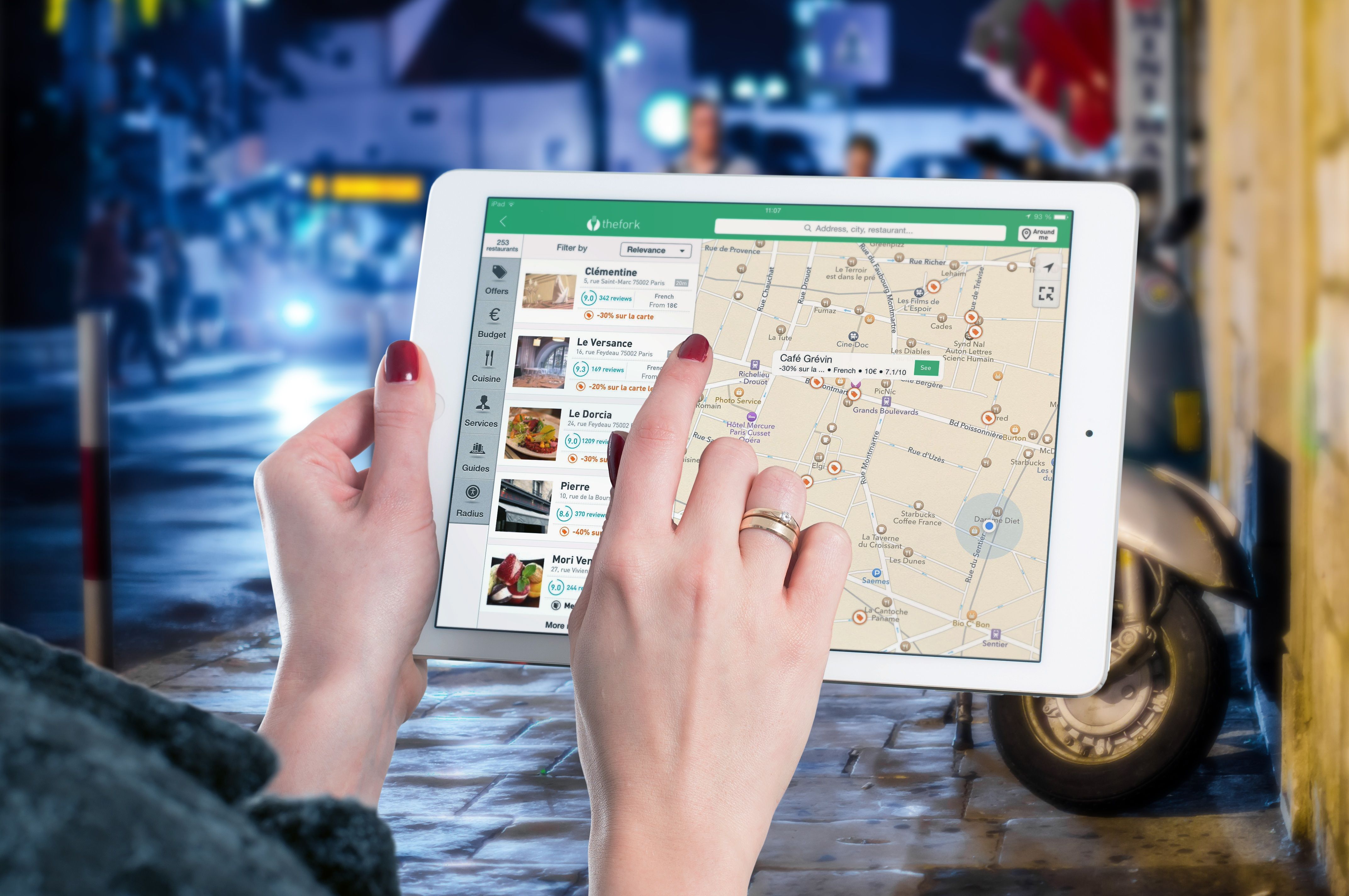 Una donna che usa l'app The Fork sul suo iPad per trovare ristoranti nelle vicinanze in Europa