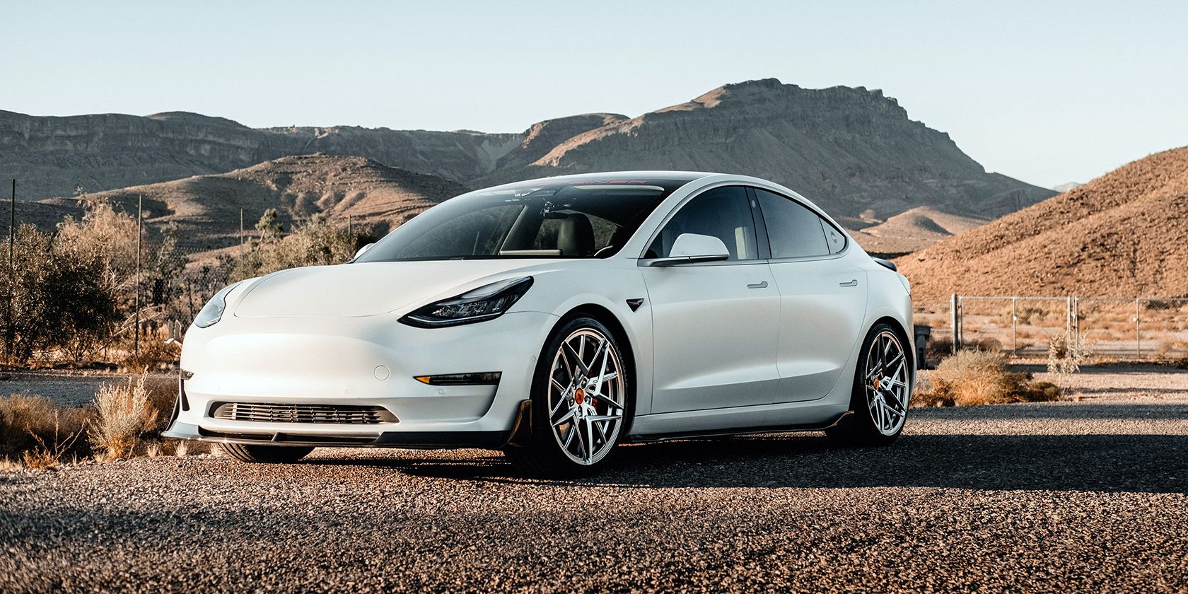 Vista laterale di una Tesla con sfondo desertico